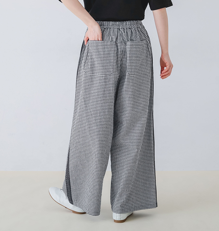 コットンリネン サイドレースセミフレアパンツの後ろ姿でウエストゴムとポケットに手を入れている