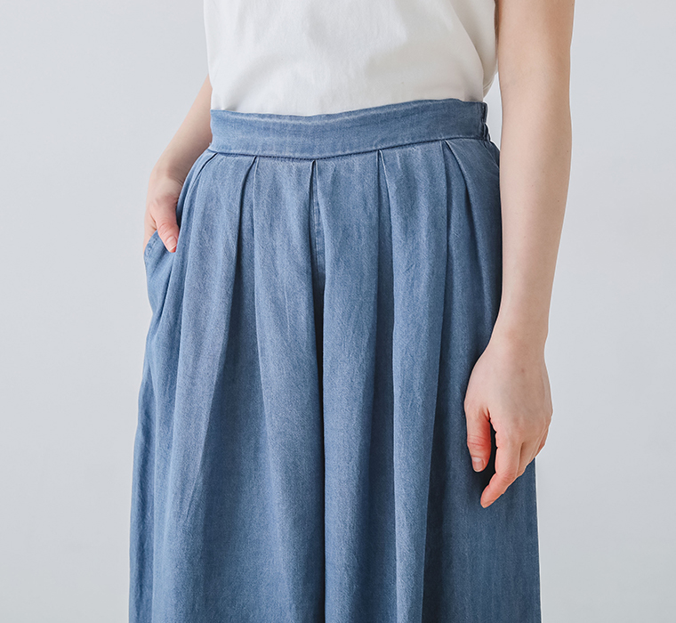 ウエストタックデニムパンツのウエスト部分のタックとポケットに手を入れている部分アップ