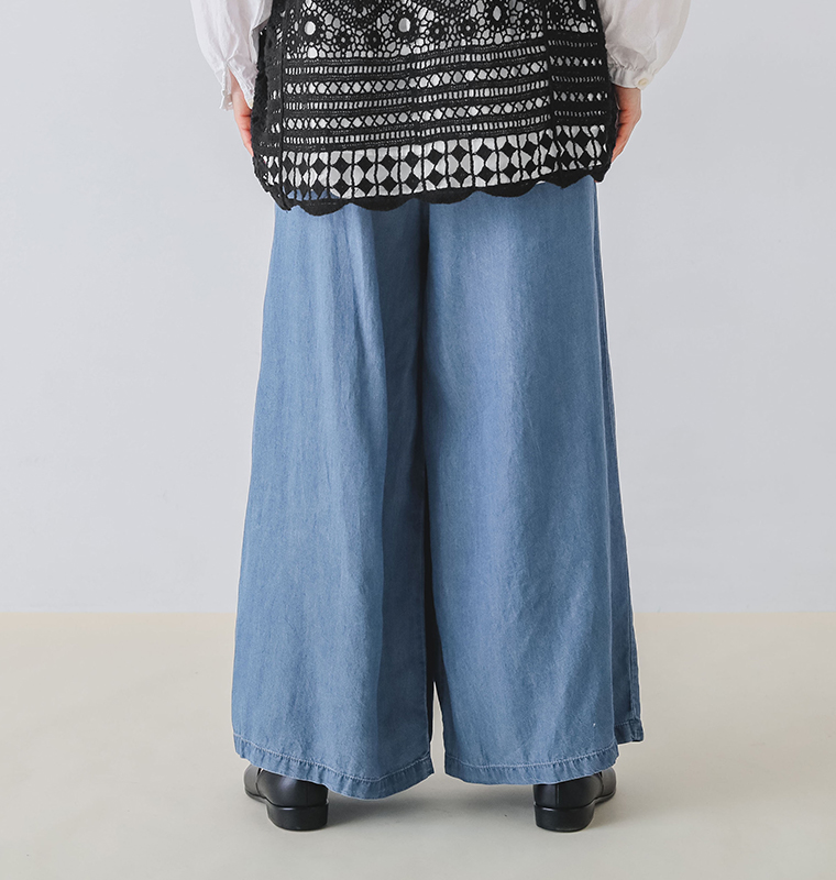 ウエストタックデニムパンツの後ろ姿で裾まで広がるシルエット