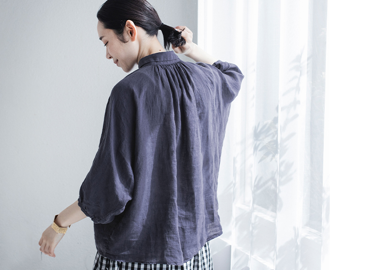 リネンキャンバスグランシャツのネイビーを着たモデルのバックスタイル