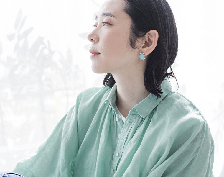リネンキャンバスグランシャツのミントグリーンを着たモデルの上半身アップ