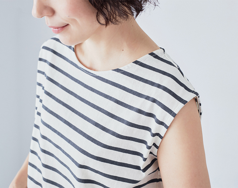 アイボリー×ネイビーのボーダー柄タンクトップを着用した上半身アップのコーディネート画像