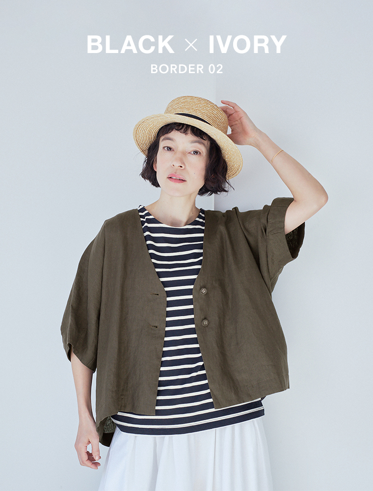 ブラック×アイボリーのボーダー柄タンクトップにオリーブの半袖ジャケットと白パンツを合わせた正面コーディネート画像