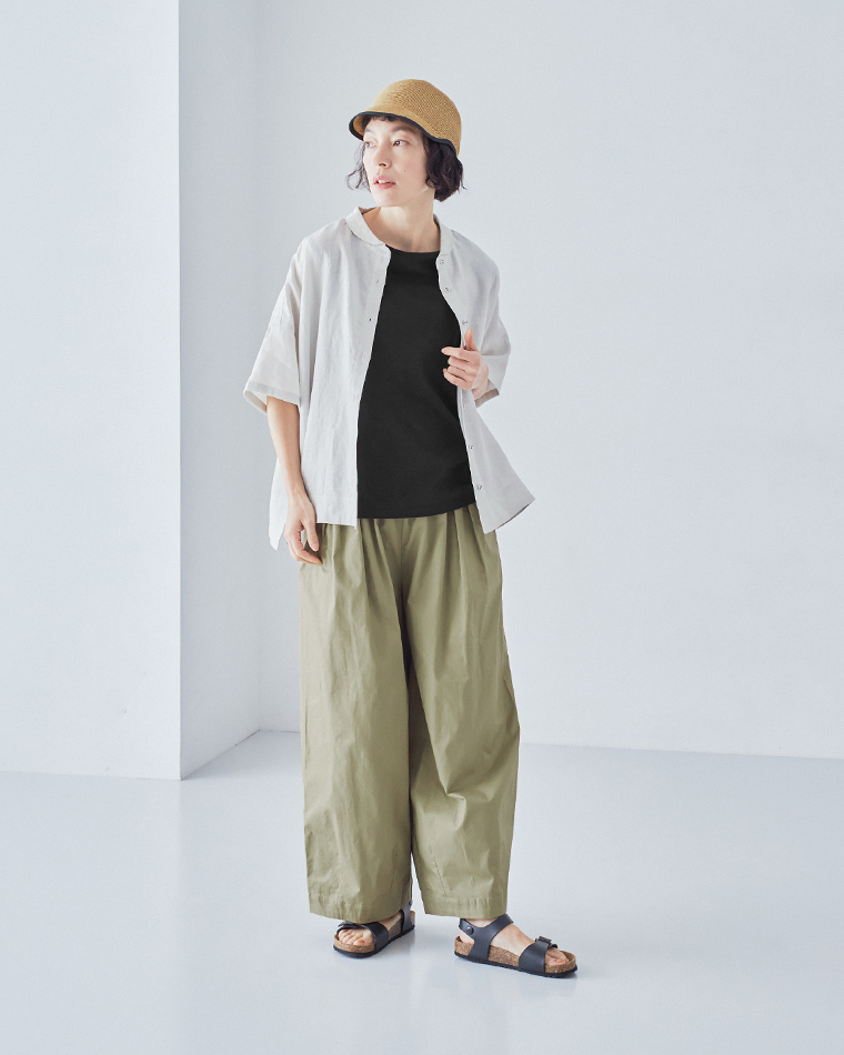 ライトカラーのシャツを羽織り、ブラックのタンクトップとライトオリーブのパンツを合わせ、つば広の帽子をかぶった正面コーディネート画像