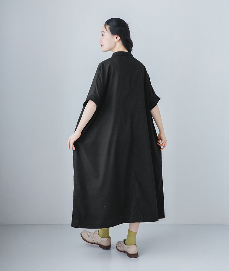 モデルがブラックのリブ袖ドルマンワンピースを着て後ろ姿で振り返っている