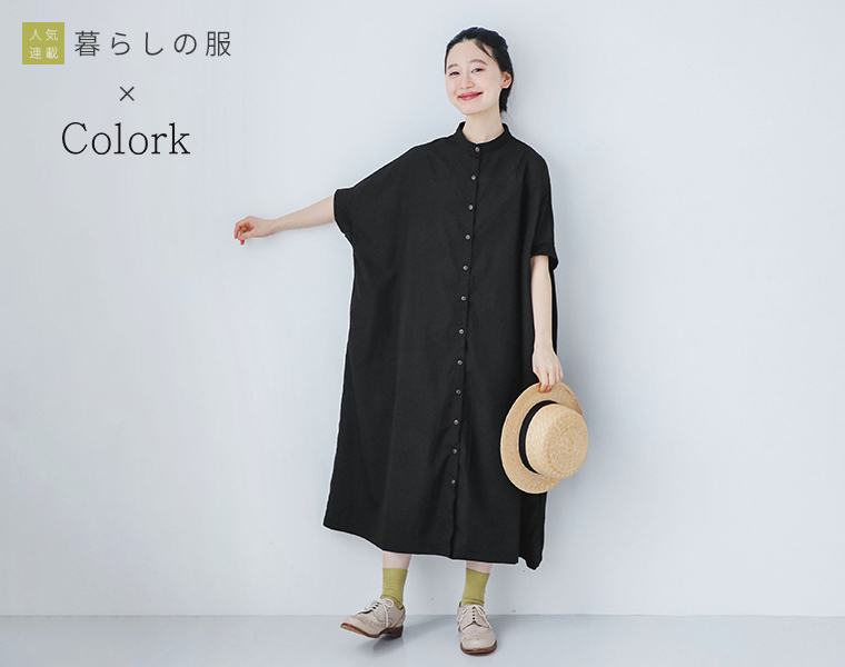 暮らしの服　モデルがブラックのリブ袖ドルマンワンピースを着て帽子を持ち正面を向いて立っている