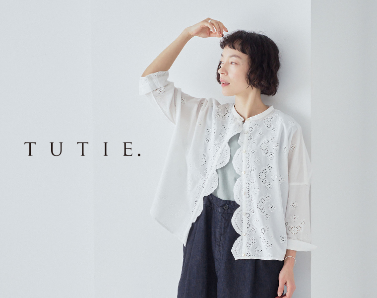 TUTIE. スカラップ刺繍レースブラウスのホワイトを着た女性モデルの上半身