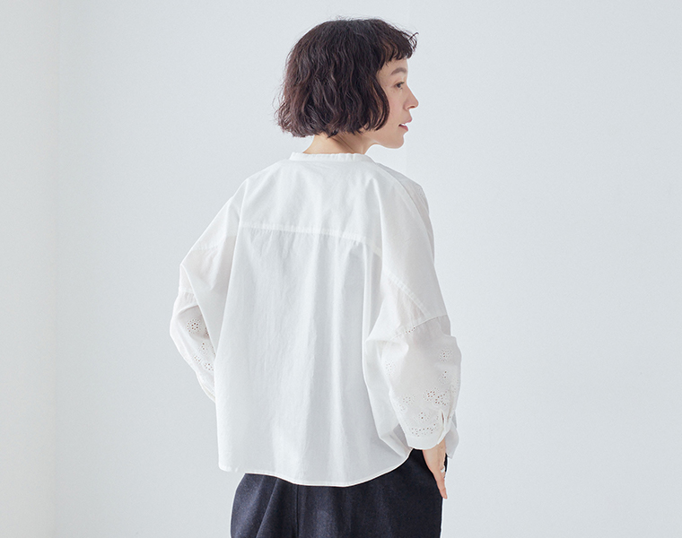 TUTIE. スカラップ刺繍レースブラウスのホワイトを着た女性モデルの後ろ姿