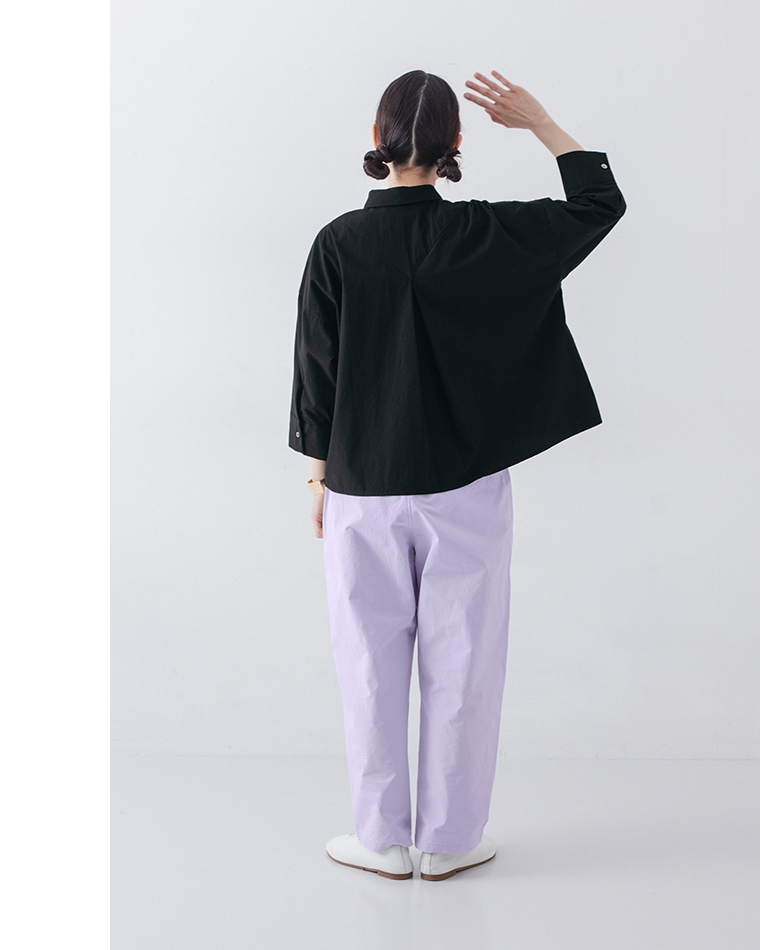 ブラックのシャツとラベンダーパンツを着た人物のバックスタイルコーディネート画像