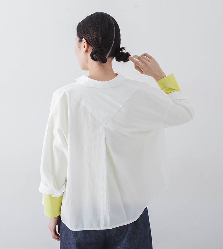 ホワイトのシャツにイエローのインナーを重ねた人物のバックスタイル着用画像