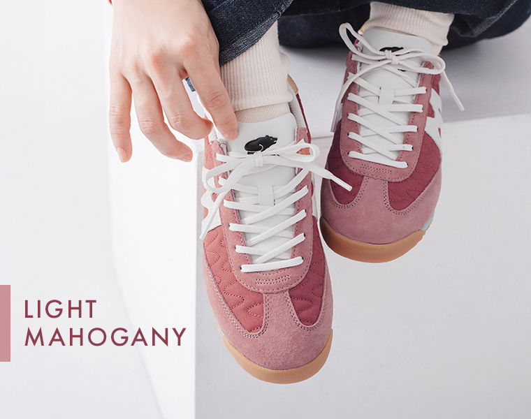 モデルがメスタリのライトマホガニーのスニーカーを履いて足元を上から写している