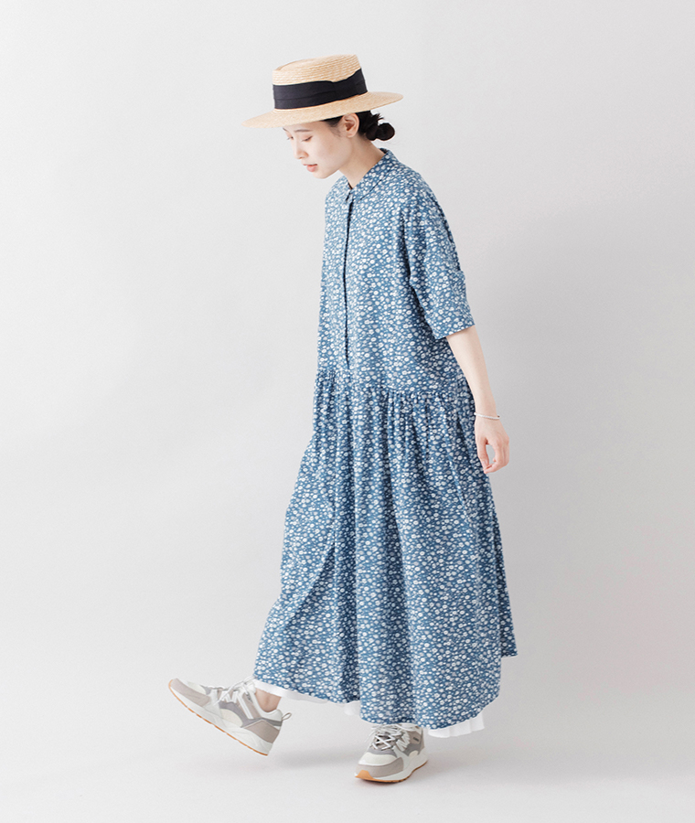 モデルがフュージョン2.0のアトモスフィアのスニーカーを履いて花柄ワンピースと帽子を合わせて歩いている