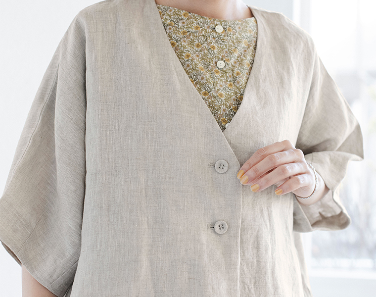 ナチュラルのリネンジャケットと花柄シャツを重ねた胸元ディテールの着用画像