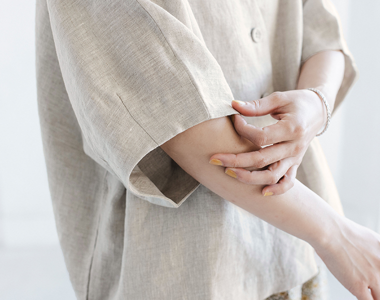 ナチュラルのリネンジャケットの袖まわりと腕のしぐさを写した着用ディテール画像