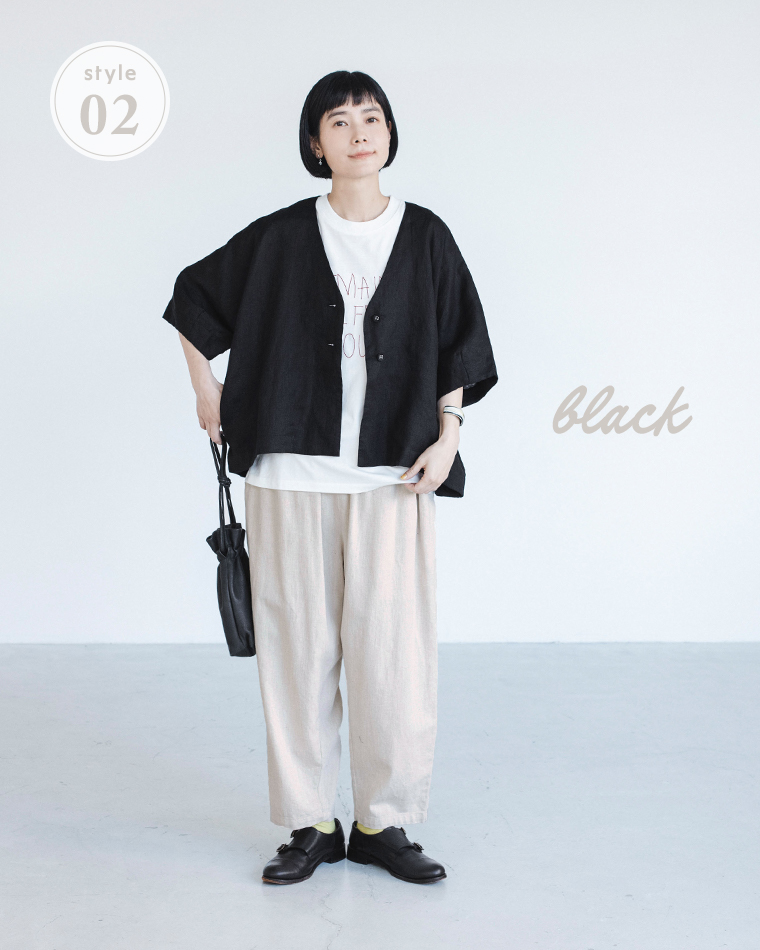 ブラックのリネンジャケットを白Tシャツとライトベージュのワイドパンツに合わせ、小さな黒バッグを持った着用コーディネート画像