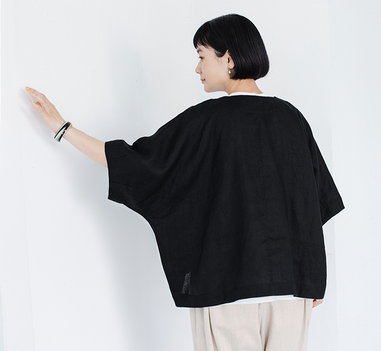 ブラックのリネンジャケットをライトカラーのパンツに合わせ、背中側のシルエットを写した着用コーディネート画像