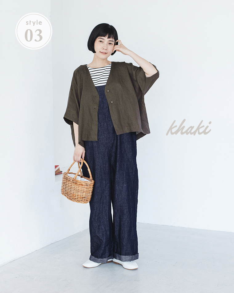 カーキのリネンジャケットをボーダートップスとデニムオーバーオールに合わせ、かごバッグを持った着用コーディネート画像
