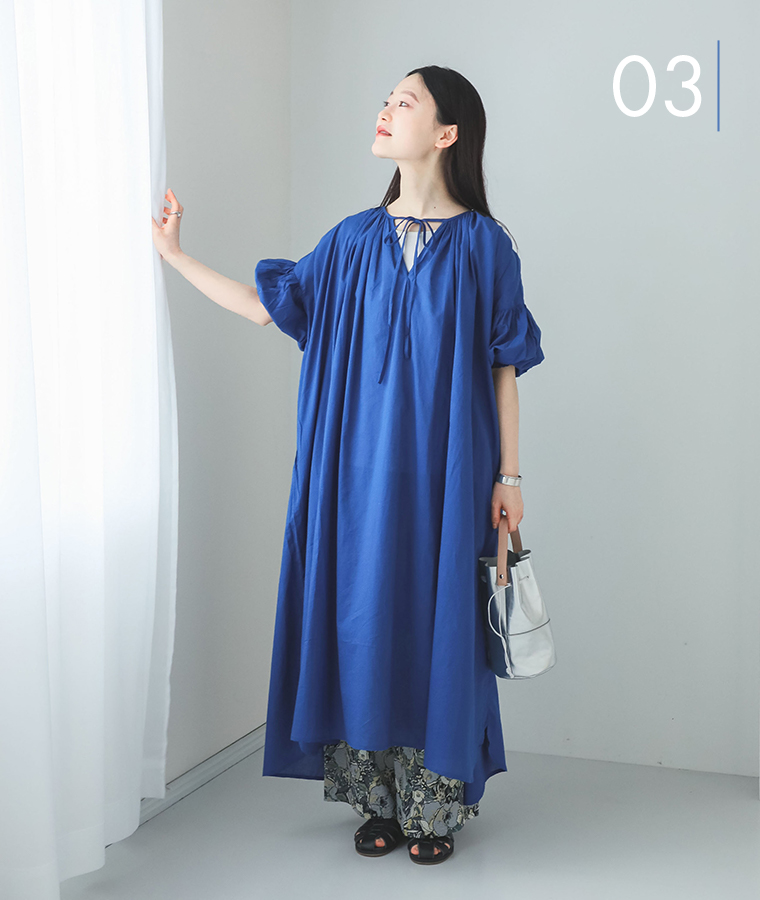 m.nのキャンブリック2way7分袖ギャザーワンピースを着てカーテンに手を添えている