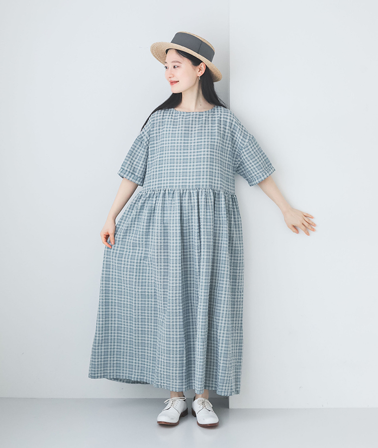 m.nの【ロング丈】サッカーウエストギャザーワンピースを着て帽子をかぶり正面を向いて立っている