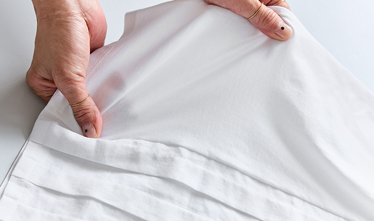 ワイトのTシャツ生地を両手で軽く引き伸ばして質感を見せた素材アップ画像