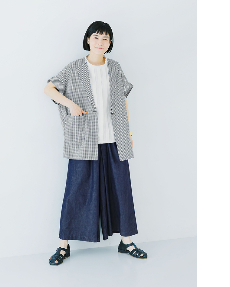 オフホワイトの半袖トップスにネイビーのワイドデニムパンツを合わせた着用コーディネート画像（かごバッグ・黒サンダル）