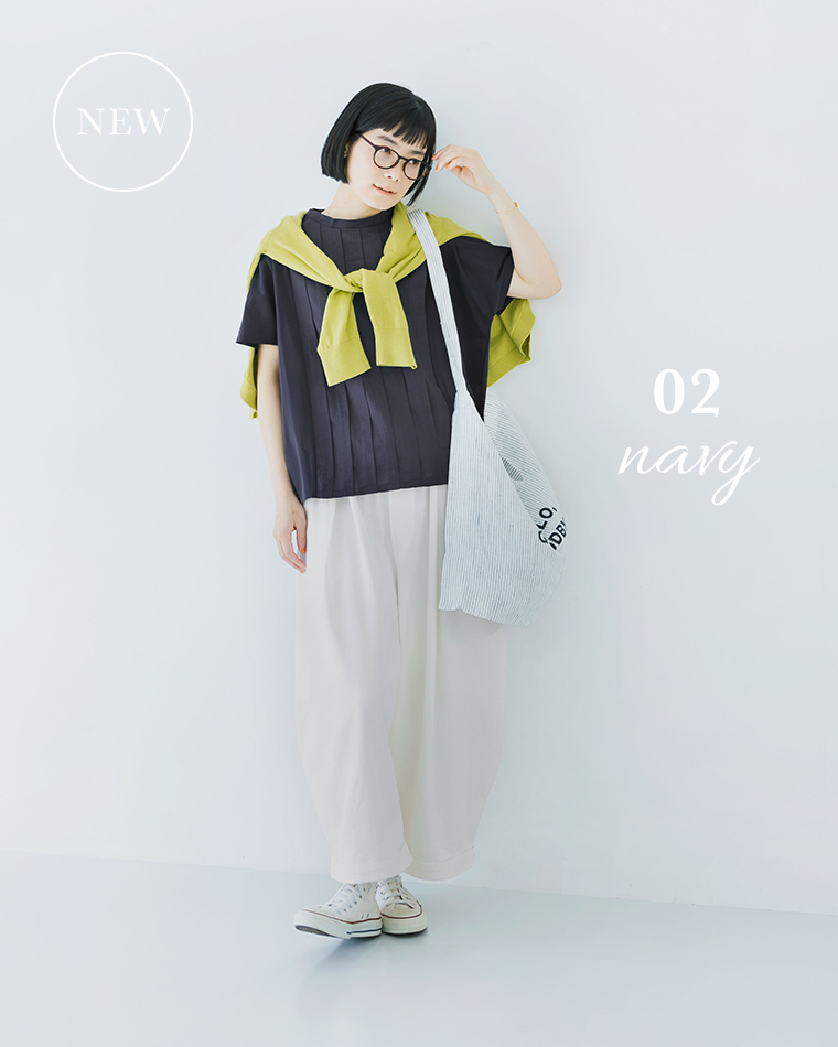 ネイビーの半袖トップスにライトグリーンの肩掛けニットと白パンツを合わせた着用コーディネート画像（白スニーカー・ストライプ柄トート）