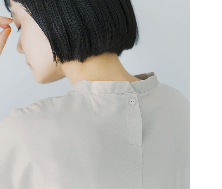 ライトグレーの半袖トップスを着用した人物の後ろ姿を写した着用コーディネート画像