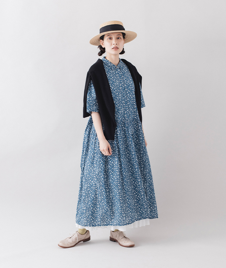 HEAVENLY フラワープリントワンピースのブルーに黒のカーディガンを肩掛けした女性モデルの全身コーディネート