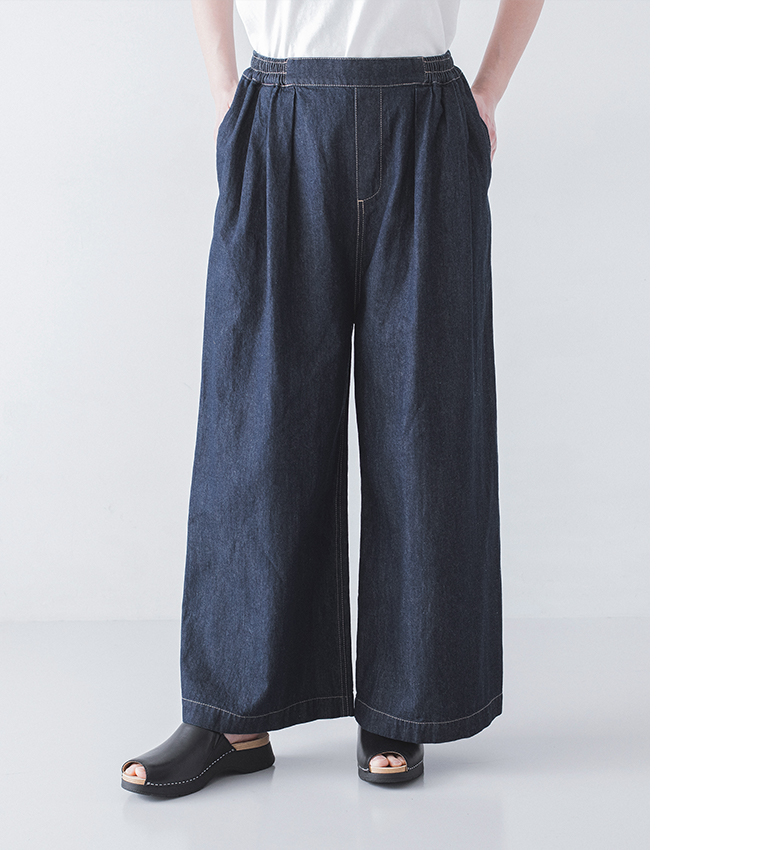 インディゴのワイドデニムパンツに白トップスと黒サンダルを合わせた着用コーディネート画像