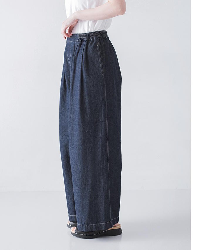 インディゴのワイドデニムパンツに白トップスと黒サンダルを合わせた横向きの着用コーディネート画像