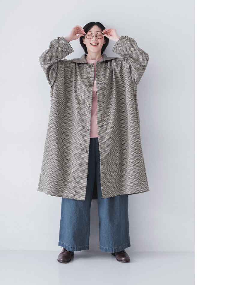 チェック柄のロングコートにピンクトップスとブリーチデニムパンツ、ブラウンシューズを合わせた着用コーディネート画像