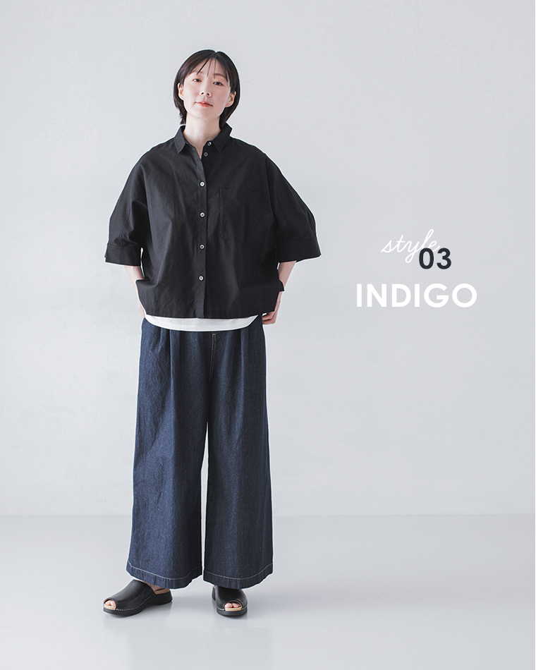 黒のボタンシャツに白インナーとインディゴのワイドデニムパンツ、黒サンダルを合わせた着用コーディネート画像