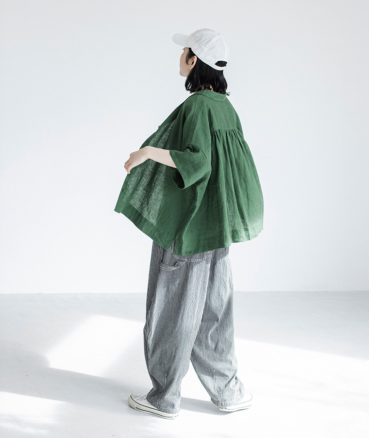 100%リネンちび襟シャツグリーンを着たモデルが後ろ姿で歩いている