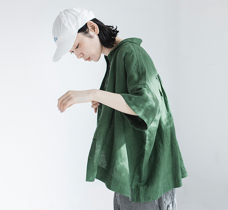100%リネンちび襟シャツグリーンを着たモデルが横向きで腕を上げている