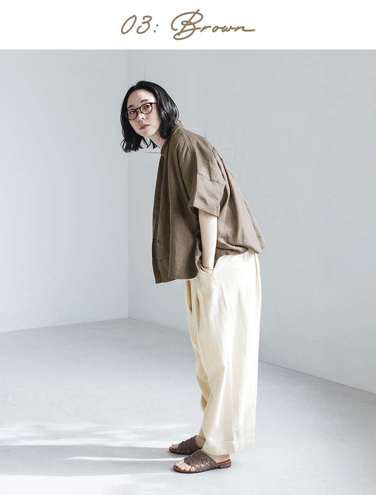 100%リネンちび襟シャツブラウンを着たモデルが前かがみで立っている