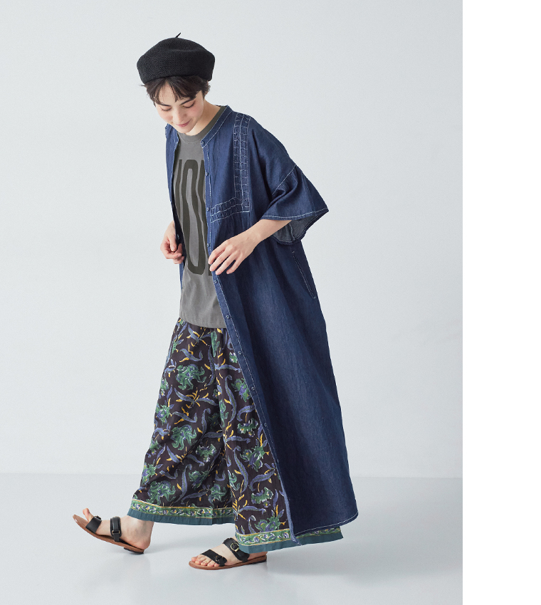 デニムスモッキングフレアワンピース(インディゴ)を羽織った全身斜めの動きのあるカット