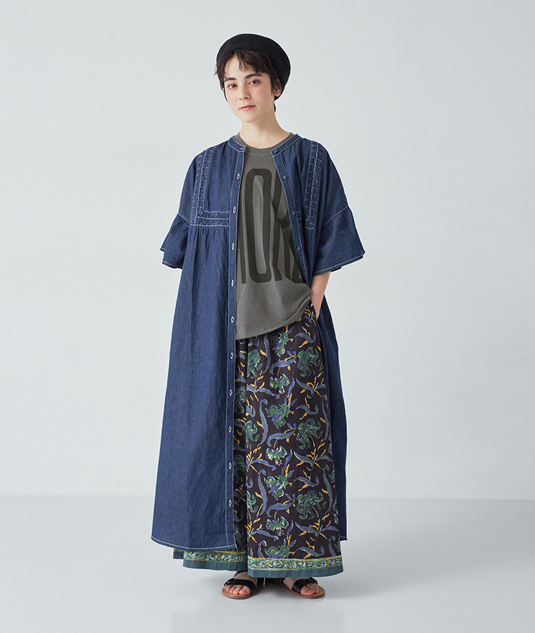 デニムスモッキングフレアワンピース(インディゴ)を羽織ってパンツのポケットに手を入れた全身カット