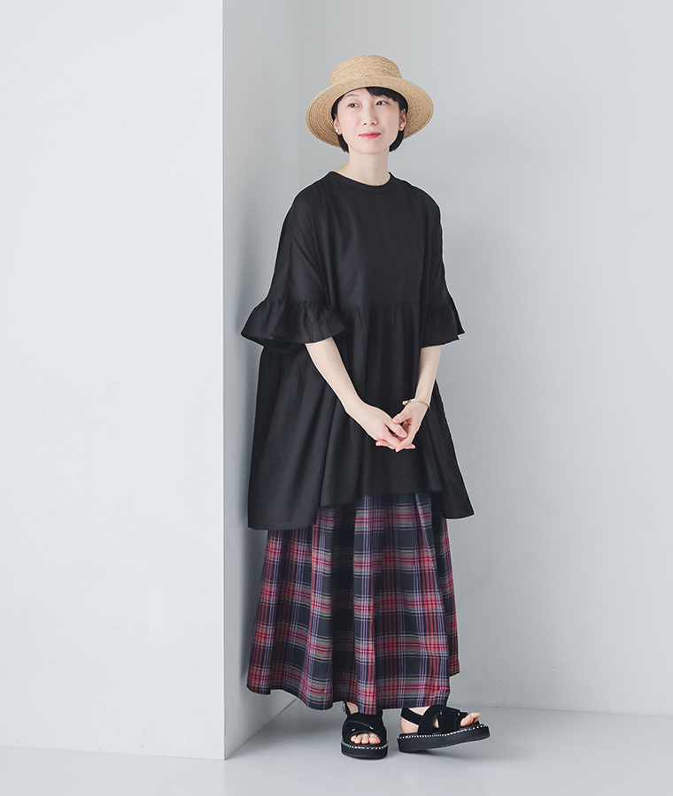 コットン2wayスクエアチュニックブラウスを着たモデルが壁にもたれて立っている