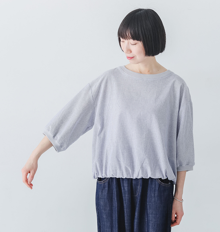 no jeanのリネンタッチころんとかわいいハーフスリーブブラウスを着たモデルが腕を伸ばしている