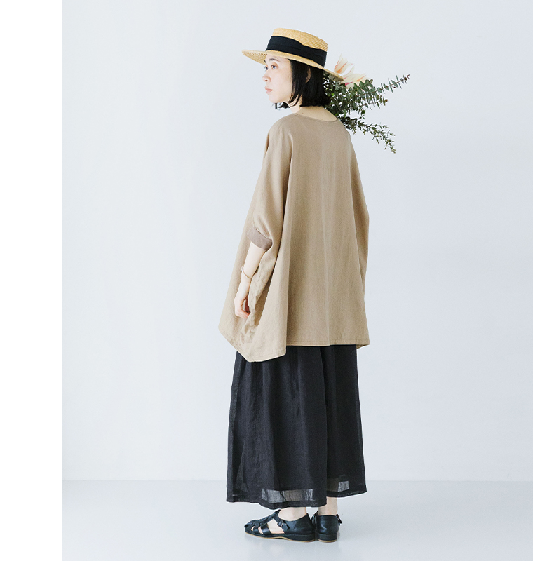 ベージュのプルオーバーに黒のシアーなロングスカートを合わせた女性モデルの全身コーディネート