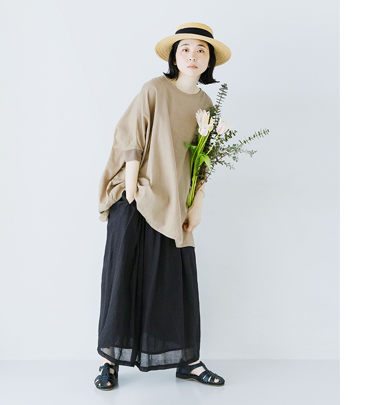 ベージュのプルオーバーに黒のシアーなロングスカートを合わせた後ろ姿のコーディネート