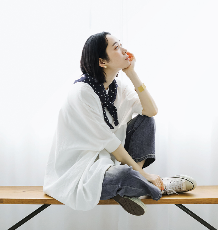 ichi コットンリネン袖リブプルオーバーブラウスのホワイトにデニムを合わせて座った女性モデルのコーディネート