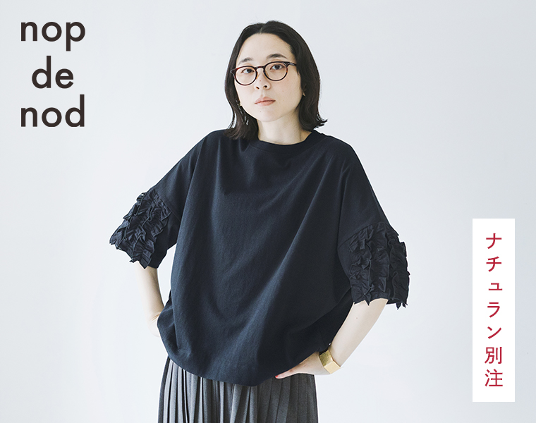 nop de nodの着るだけでサマになる フリル5分袖Tシャツ ブラックを着たモデルが腰に手を当てている