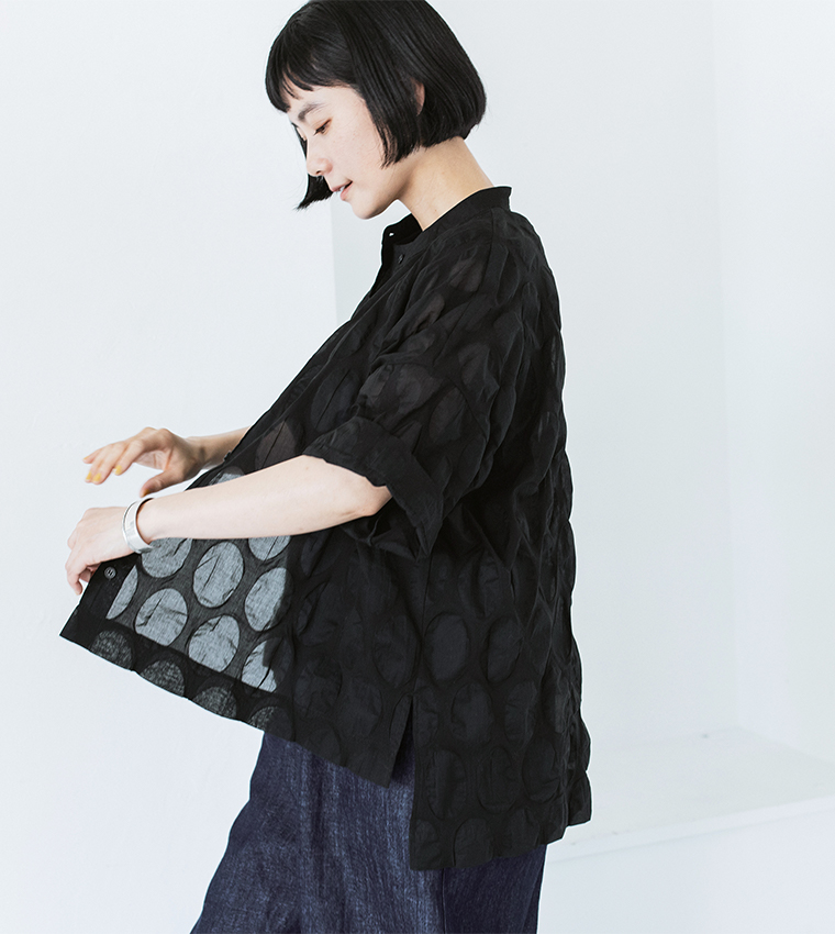 ブラックのシアーシャツを着た人物の横向きカット（裾の前後差とサイドスリットでバランスを整えたデザイン）