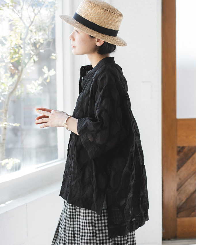 ブラックのシアーシャツにチェック柄ワイドパンツを合わせた人物の横向きコーディネート画像