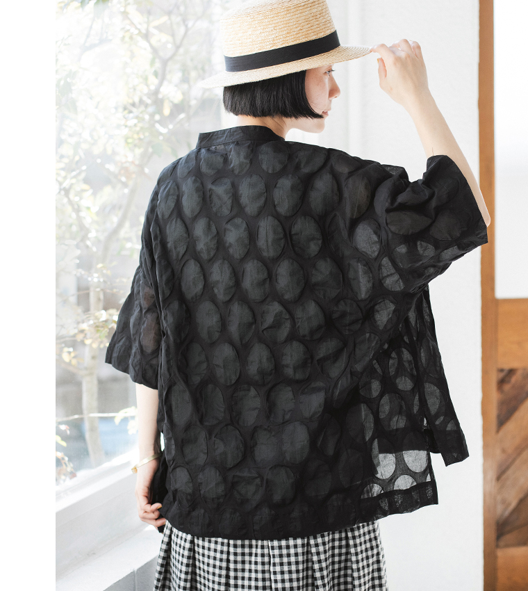 ブラックのシアーシャツにチェック柄ワイドパンツを合わせた人物のコーディネート画像（楕円ドット柄の透け感が見えるデザイン）