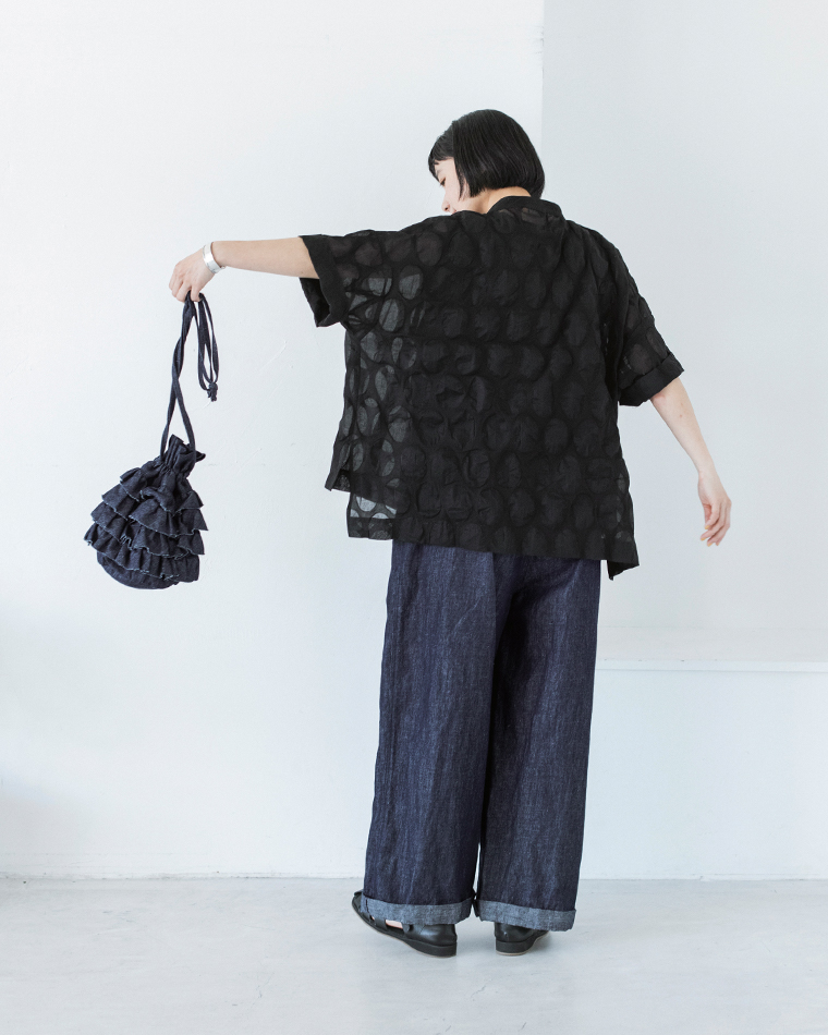 ブラックのシアーシャツにサロペットを合わせた人物の後ろ姿コーディネート画像