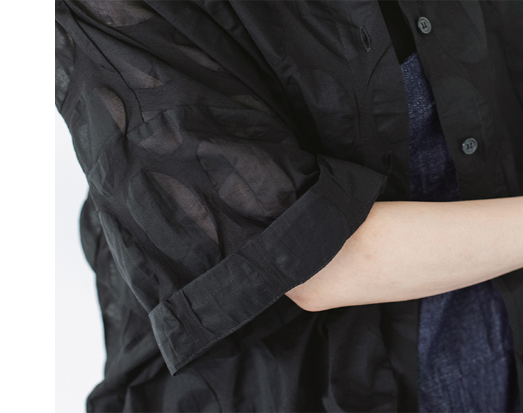 ブラックのシアーシャツの袖まわりを写した質感アップ（楕円ドット柄と軽やかな透け感が見えるカット）