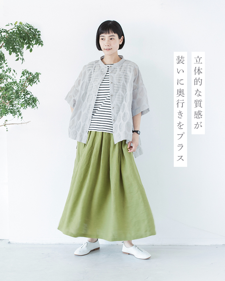 ライトグレーのシアージャケットにボーダートップスとカーキのロングスカートを合わせた人物のコーディネート画像（立体的な質感が装いに奥行きを添えるデザイン）