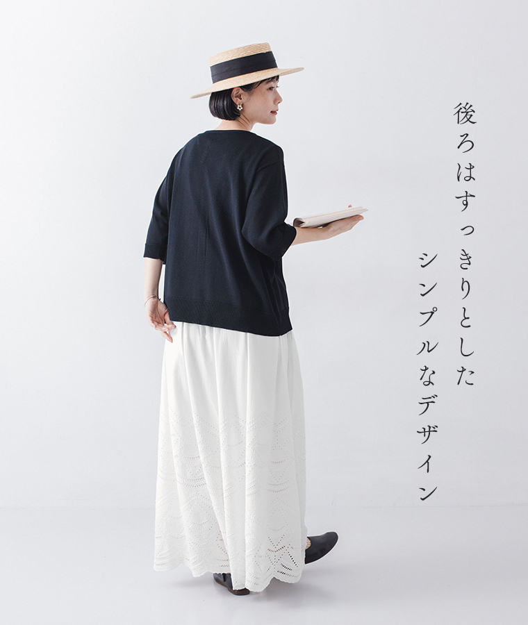 5分袖ニットカーディガン ネイビーを着たモデルが本を持って後ろを向いている